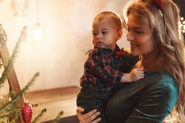Genç mutlu anne ve küçük tatlı oğlu Noel 'i ya da yeni yılı kutluyorlar..
