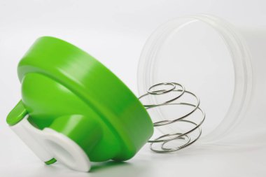 Beyaz zemin üzerinde karıştırma topu ile yeşil protein karıştırıcı