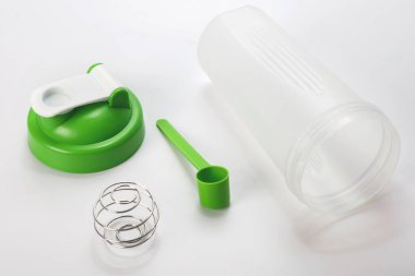Yeşil protein karıştırıcı ve beyaz arkaplanda kepçe