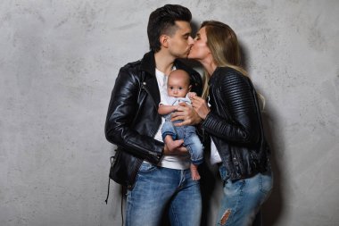 Genç ve şık bir aile. Mutlu anne ve baba ve küçük bebek.