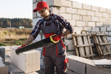 Profesyonel tuğla ustası otomatik klavyeli beton blokları kesiyor