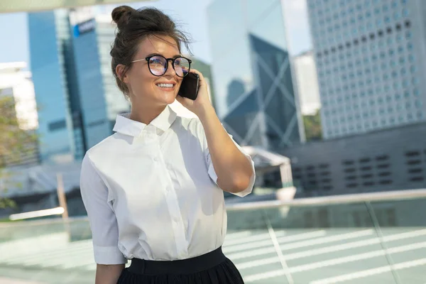 Genç Kadını Şehirde Modern Binaları Olan Akıllı Telefon Kullanıyor — Stok fotoğraf