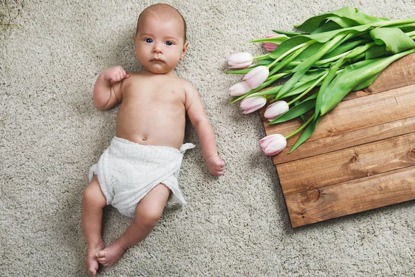 Niedliches Kleines Baby Liegt Auf Dem Boden Neben Dem Strauß — Stockfoto