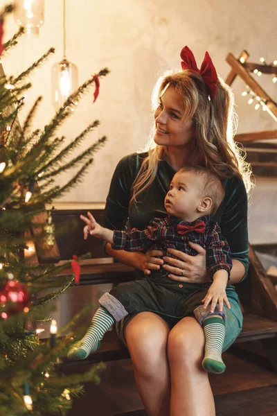 若い幸せな母親と彼女のかわいい息子はクリスマスや新年を祝っています — ストック写真