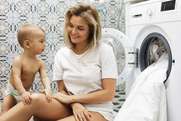 快乐的妈妈和她的小儿子正在装洗衣机 — 图库照片