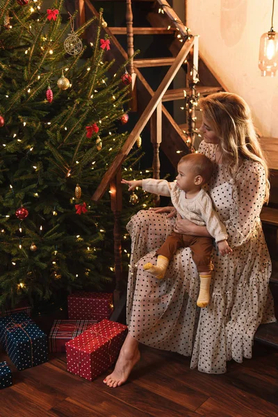 若い幸せな母親と彼女のかわいい息子はクリスマスや新年を祝っています — ストック写真