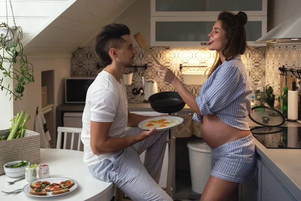 年轻夫妇和幸福的夫妇都在等着孩子 早餐时 丈夫和他怀孕的妻子在厨房里 — 图库照片