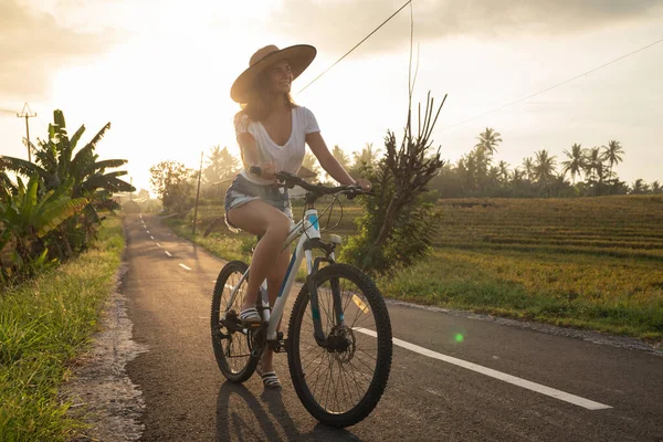 Genç Mutlu Kadın Dar Kırsal Yolda Bisiklet Sürüyor — Stok fotoğraf