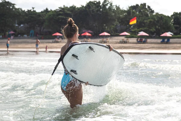 疲れた女サーファーはサーフィンの練習の後海から海岸に出て行く — ストック写真