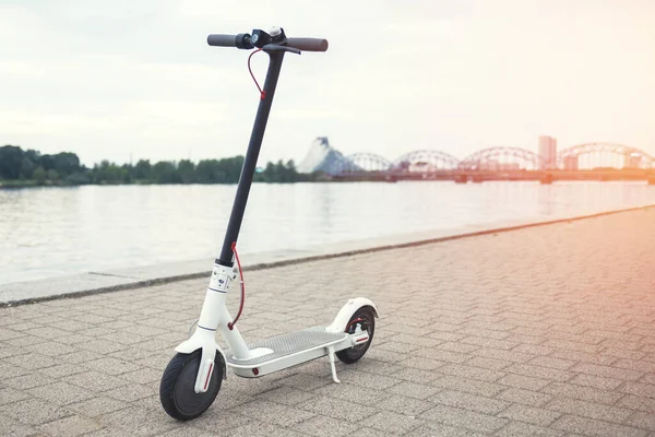 Modern electric scooter on the riverside of city