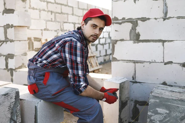 Thoughtful professional bricklayer at the construction site