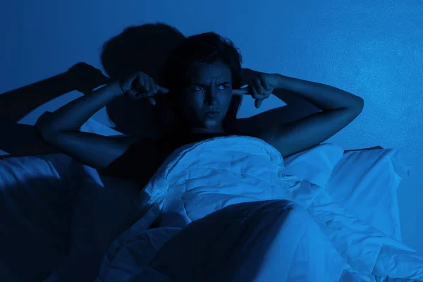 Woman with insomnia because of loud noises in the bedroom
