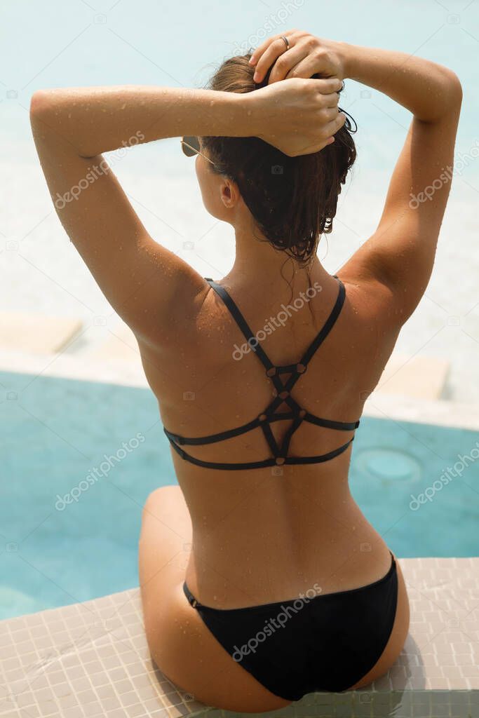 Sexy woman relaxing in the pool during her summer holidays