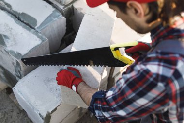 Profesyonel tuğla ustası otomatik klavyeli beton blokları kesiyor