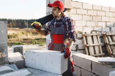 Profesyonel tuğla ustası otomatik klavyeli beton blokları kesiyor