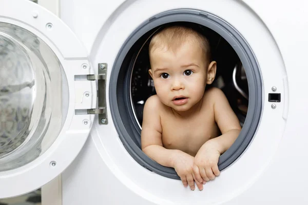 可爱而好奇的小男孩坐在洗衣机里 — 图库照片