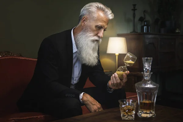 Elegante Guapo Barbudo Hombre Mayor Está Mirando Reloj Arena — Foto de Stock