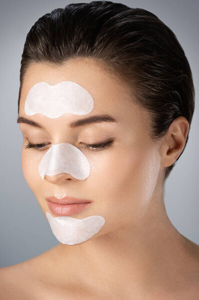 Young and beautiful woman with a cleansing pore strips on her face