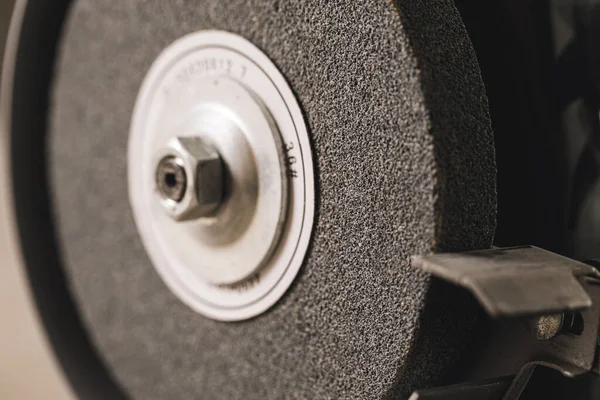 Close-up of abrasive disc on bench grinder machine