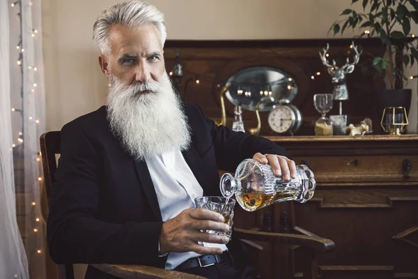 Stílusos Jóképű Szakállas Idősebb Férfi Whiskyt Önt Üvegbe — Stock Fotó