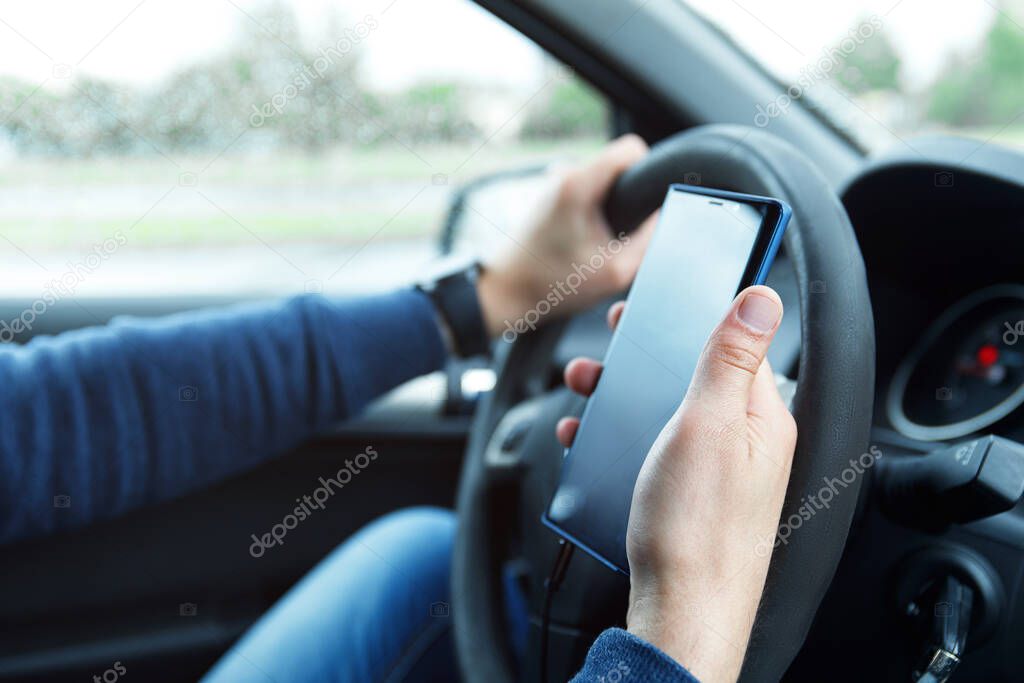 Man in car is using smartphone. Concepts of ridesharing, driving safety or GPS navigation.
