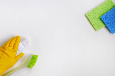 Plastik şişelerdeki Deterjanlar. Beyaz arka planda yeşil ve sarı temizlik malzemeleri var. Üst Manzara. Kapat..