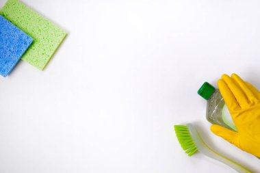 Beyaz arka planda yeşil ve sarı temizlik malzemeleri var. Sprey deterjanlar. Üst Manzara. Kapat..