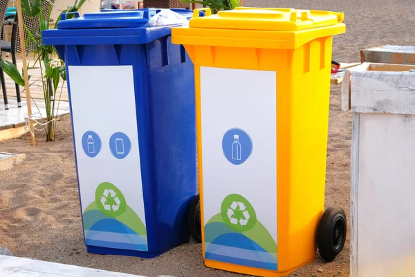 Blue and yellow containers for further processing of garbage. Garbage collection. Waste recycling concept.