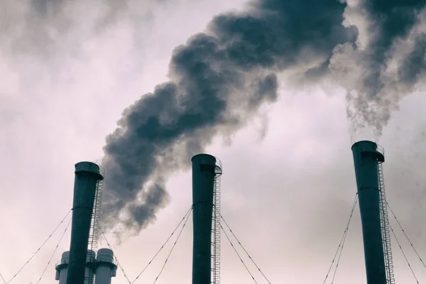 Tuberías en la ciudad con humo, sobre un fondo gris del cielo. Env. —  Fotos de Stock