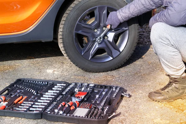 Closeup picture of mechanical tools box. Car driver using different repair tools for repairing and diagnostic an orange car. Tool set near the auto.
