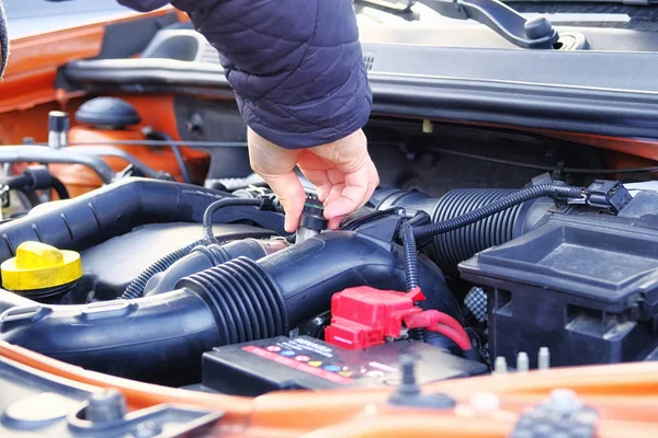 Car diagnostic and repair concept. Hands of driver checks car, open hood. Auto and vehicle servicing, close up.