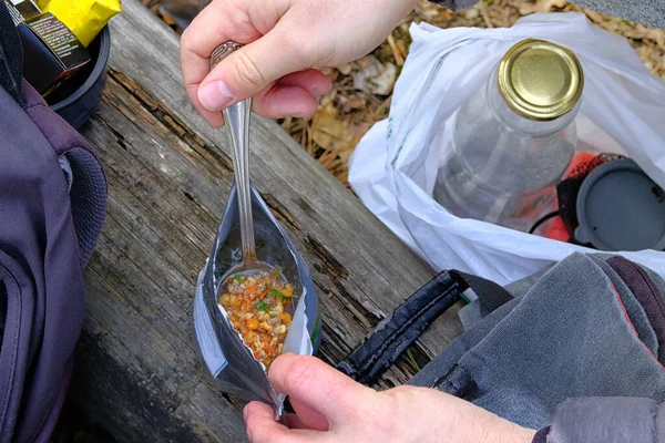 Turistler dinlenirken dondurulmuş kuru yiyecekler yiyorlar. Yürüyüş sırasında lezzetli bir yemeğin tadını çıkar. Açık hava aktiviteleri için yiyecek çantada, yakın çekim..