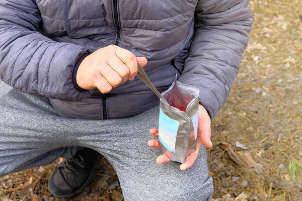 Sırt çantası kamp sırasında dondurulmuş kuru yiyecekler yiyor. Seyahat tatilinde lezzetli bir yemeğin tadını çıkar. Açık hava aktiviteleri için yiyecek çantada..