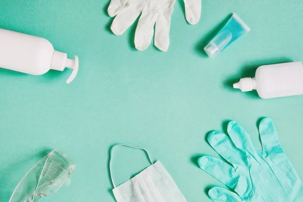 Coronavirus önleme. Üst düzey tıbbi maske, el dezenfektanı jeli, eldivenler ve mavi arka planda el hijyen koronası virüsü koruması için gözlük. Metin için alanı kopyala.