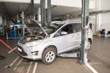 Donetsk, Ukrayna-2019. Kaputu açık gri bir araba tamirhanede bekliyor.