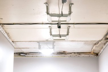 Tavan lambalarının kurulumu. Apartmandaki tamirat sırasında tavana elektrik kabloları döşediler. Bir uzman elektrik işi yapıyor.