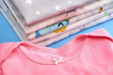 Yeni doğanların bakımı için bebek bezi ve havlu yığını. Bebek kıyafetleri.