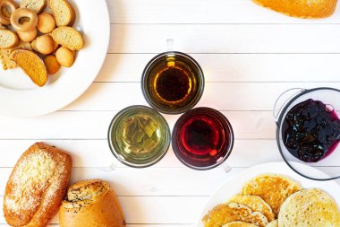 Masada ev yapımı kekler, krakerler, kurabiyeler, çörekler, pastalar, reçel, çay var. Düz plan, üst manzara. sağlıklı beslenme konsepti, sağlıklı kahvaltı.