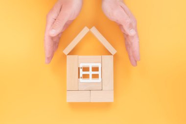 Ev ellerde. Ev güvenliği kavramı. Emlak sigortası. Evini inşa etmek, düz uzanmak. aile koruması