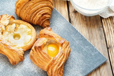 Şeftalili ve ananaslı çörekler, yakın plan, tahta bir masada, düz bir şekilde. Ev yapımı pişirme. Kafede hafif bir kahvaltı. Meyveli kruvasan.