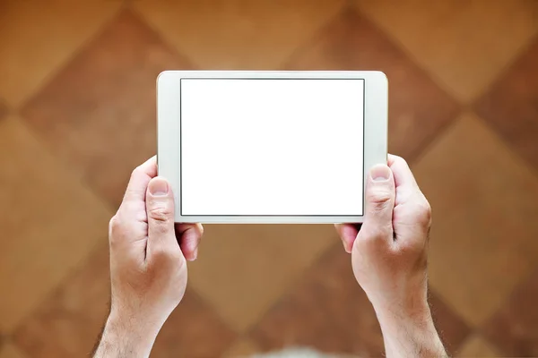 hands holding a tablet with a white screen, top view, close-up