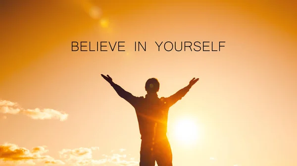 Believe in yourself concept. silhouette of a man with arms raised to the sky