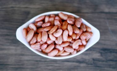 Ahşap arka planda kırmızı böbrek fasulyesi.