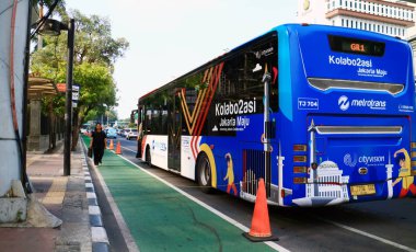 Jakarta, Endonezya - 26 Kasım 2019: Jalan Mh Thamrin 'de ücretsiz Transjakarta otobüsü. Endonezya Bankası 'nın önünde.
