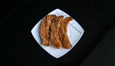 Muz, beyaz tabakta çıtır çıtır, siyah arka planda.. 