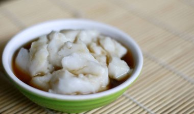 Bubur sumsum on bambbo background. Indonesian traditional porridge made from rice flour served with brown sugar syrup.