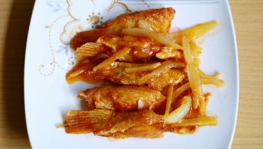 Beyaz tabakta tatlı ve ekşi somon yüzgeci. Endonezya yemekleri.