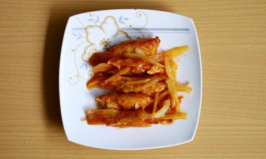 Beyaz tabakta tatlı ve ekşi somon yüzgeci. Endonezya yemekleri.