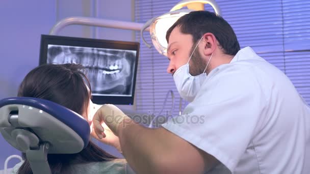 Tandläkare behandlar kvinnliga patienter tänder med hjälp av olika verktyg — Stockvideo