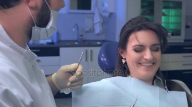Bir hasta tedavi ve hasta gülüyor sırasında diş hekimi şakalar